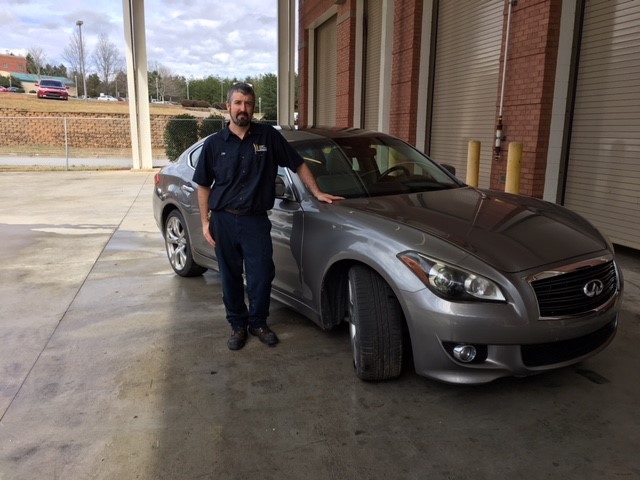 Infiniti car with Chip Comley in garage