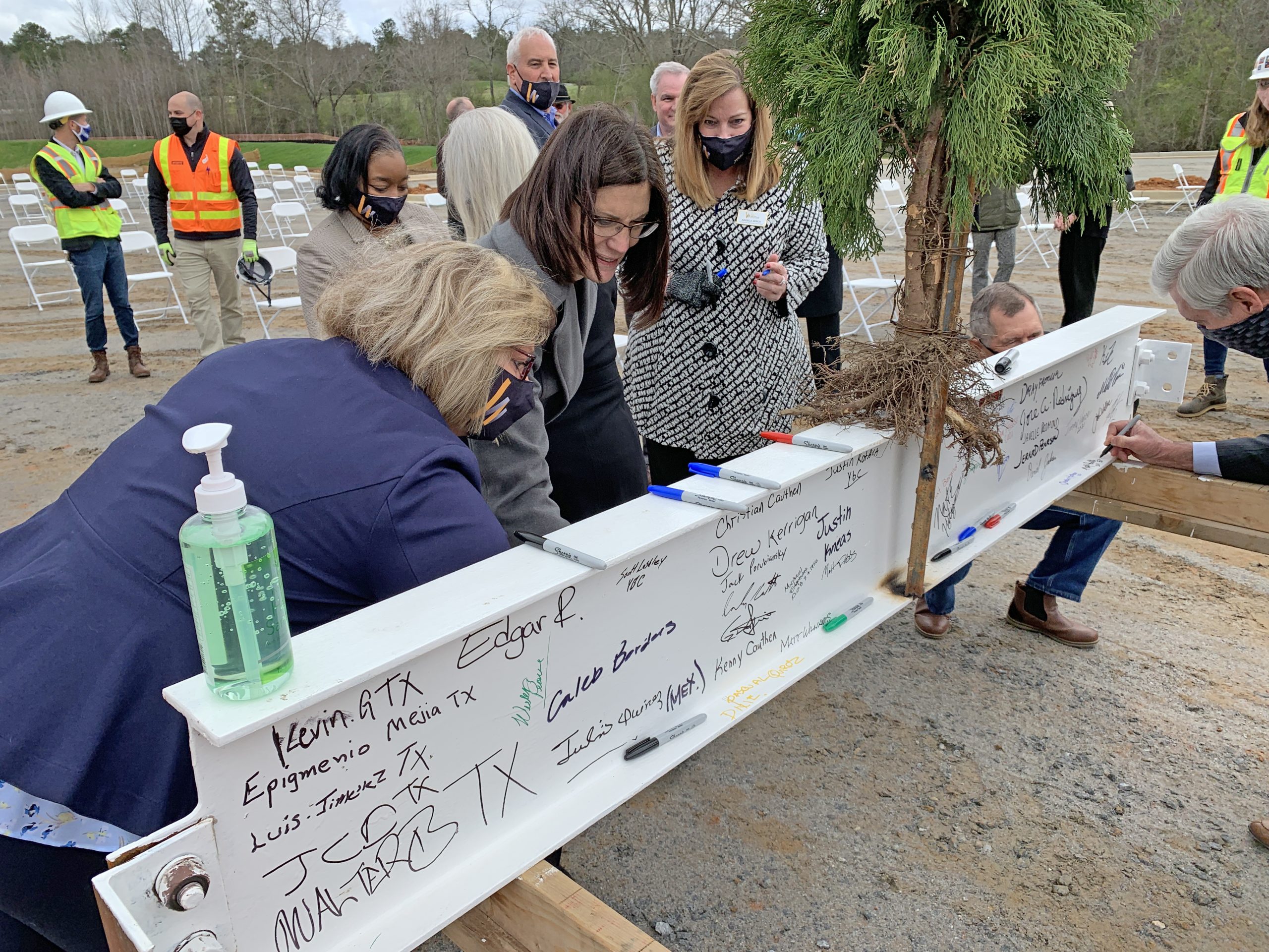 WGTC staff signs beam with tree