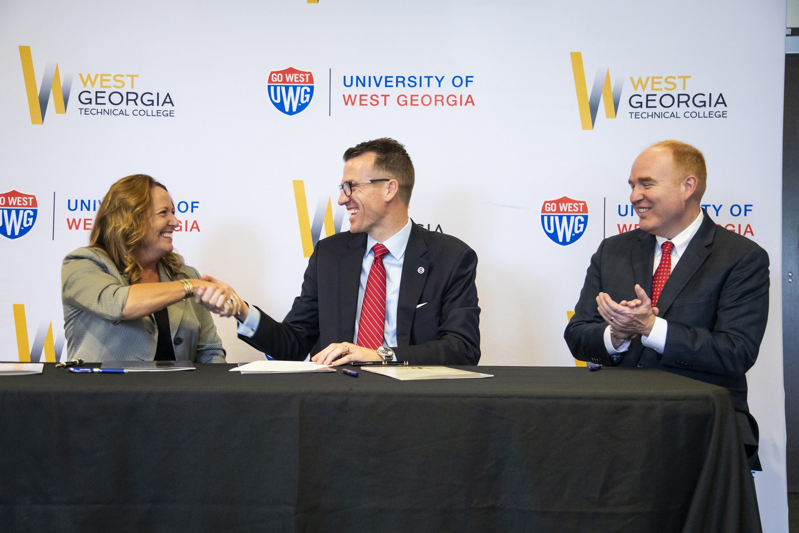 West Georgia Technical College President Dr. Julie Pos, shakes hands with University of West Georgia President Dr. Brendan Kelly as UWG’s Provost and Senior Vice President Dr. Jon Preston looks on.