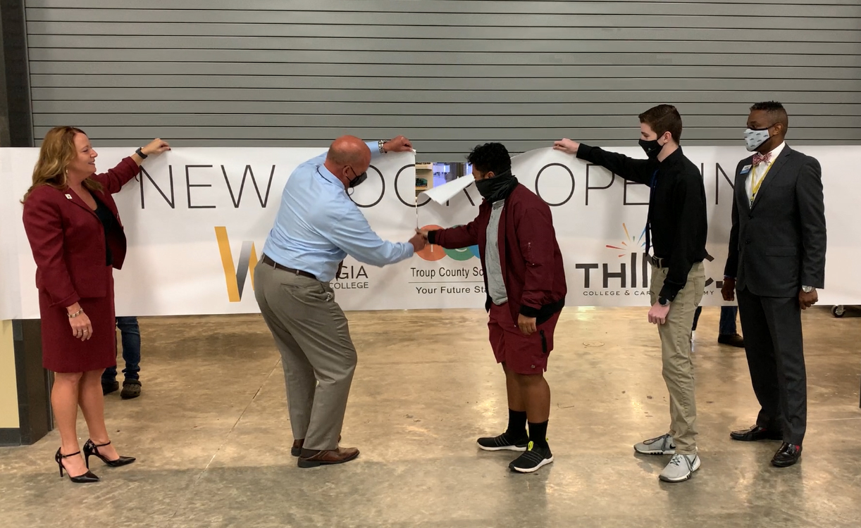 WGTC President Dr. Julie Post, Troup County Schools Superintendent Dr. Brian Shumate and THINC Academy CEO Gerald Wyatt cut through a banner separating two labs on the West Georgia Technical College LaGrange Campus.