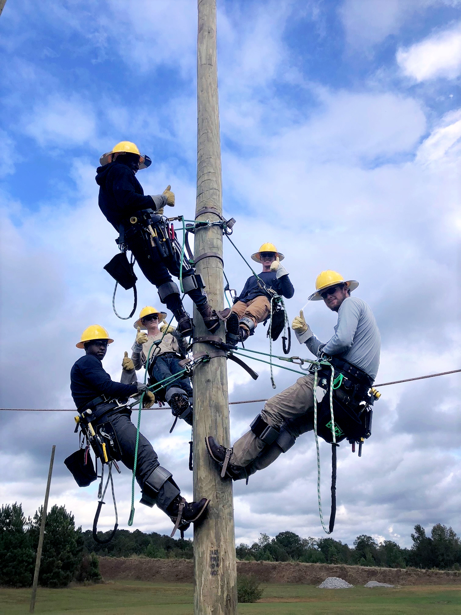 linemen on telephone pole working on power lines