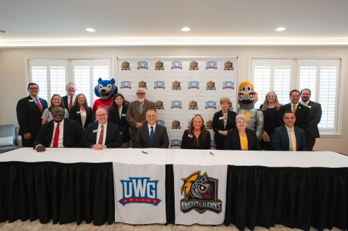 Members from both colleges behind the signing table