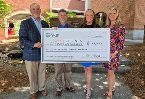 Carroll EMC holding a large check