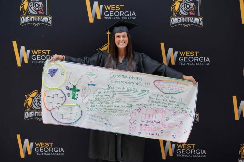 GED Student holding a sign made by her family