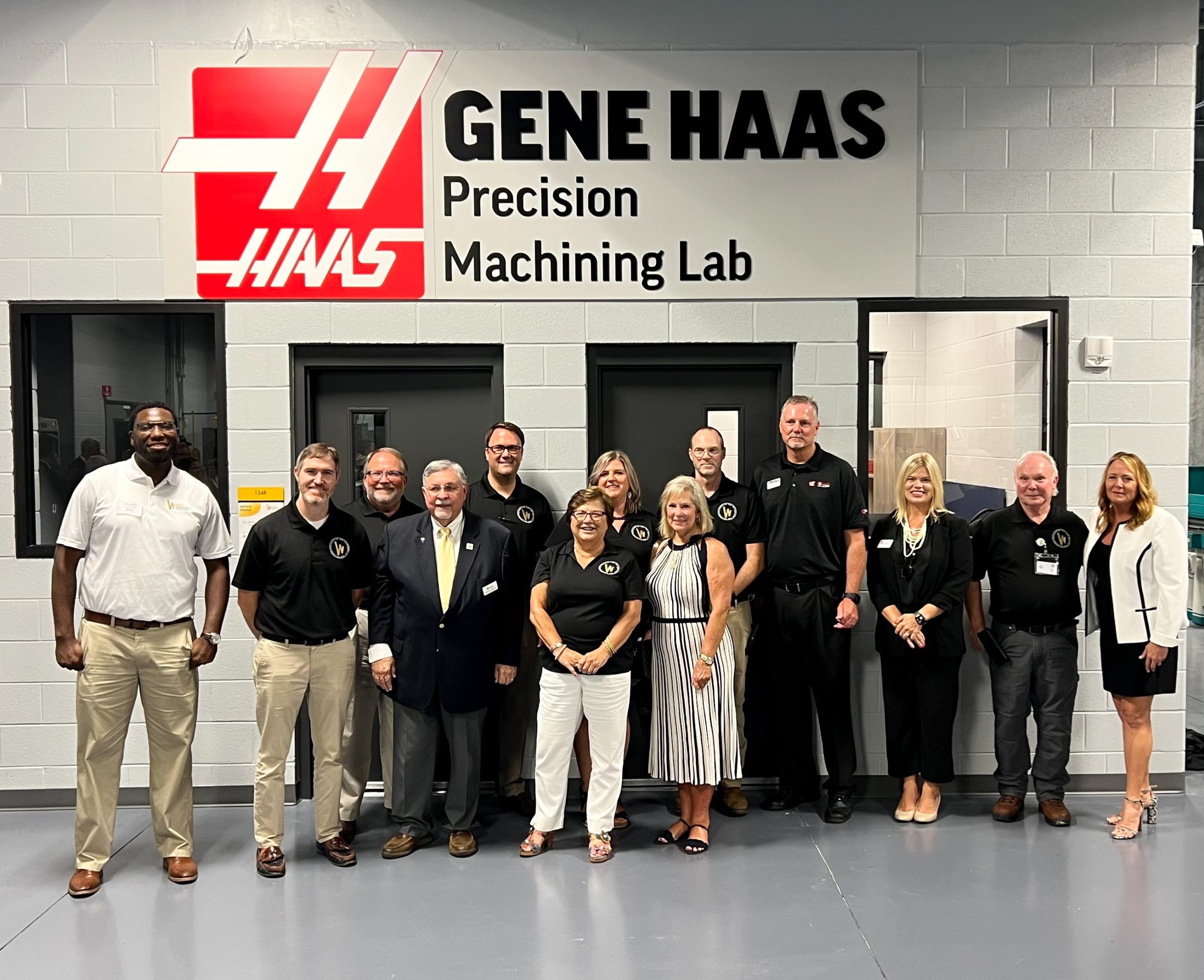Individuals standing in front of Haas Precision Machining Lab
