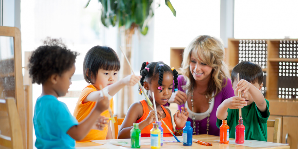 early childhood instructor helping students paint