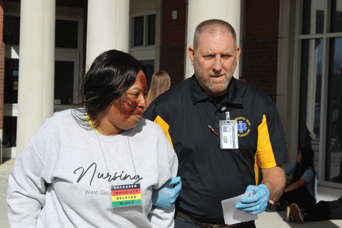 Photo of nursing student and instructor acting out trauma scenario