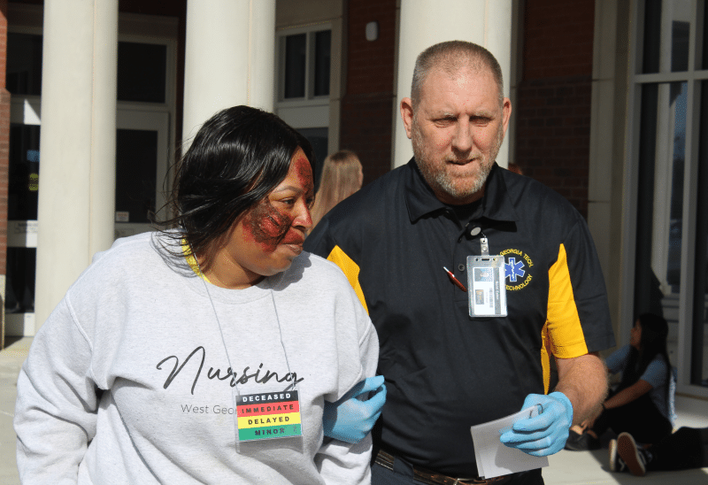 Photo of nursing student and instructor acting out trauma scenario