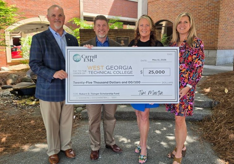 Carroll EMC holding a large check