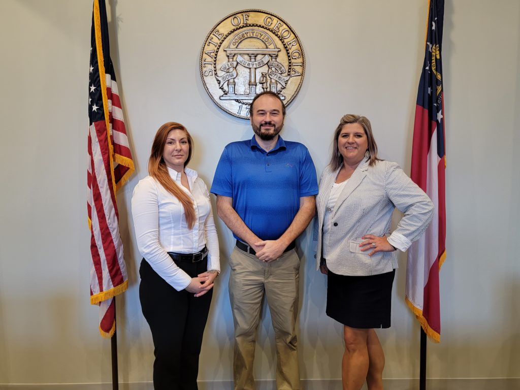 Tritt family standing in front of state of georgia plaque