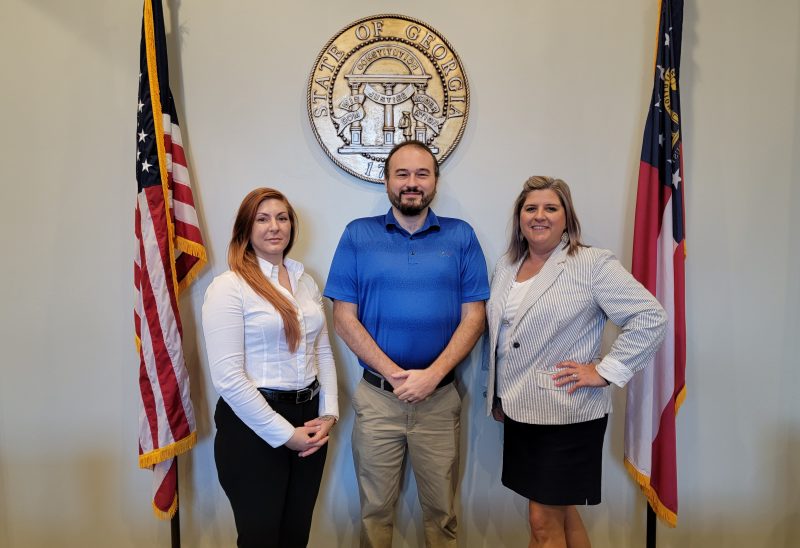 Tritt family standing in front of state of georgia plaque