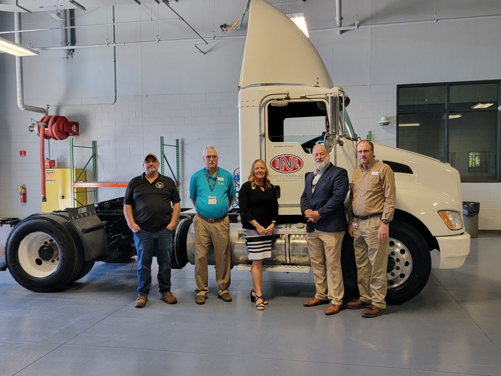 Individuals standing in front of new donated truck