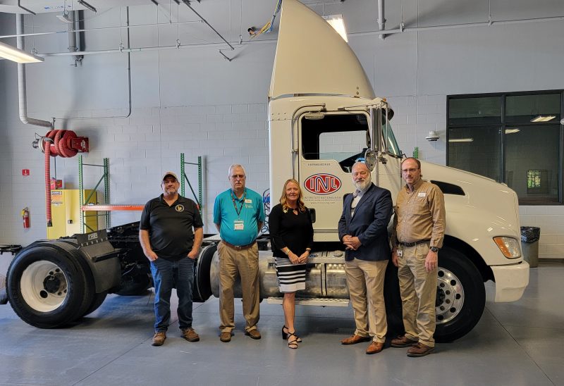 Individuals standing in front of new donated truck